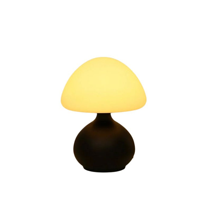 Candeeiro de mesa preto aceso com luz amarela, design contemporâneo e base arredondada.