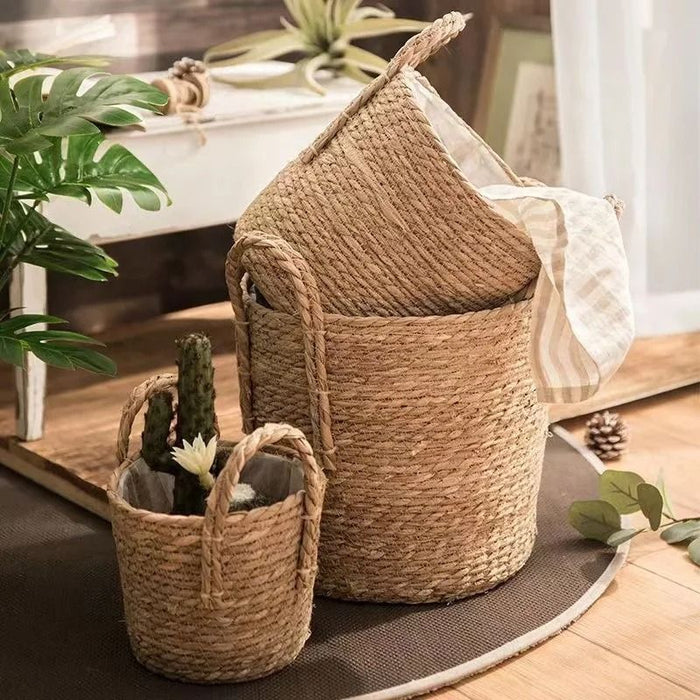 Cestos de palha natural em tamanhos diferentes, com alças resistentes, ideais para organização doméstica ou como cachepôs para plantas decorativas em estilo boho chic.